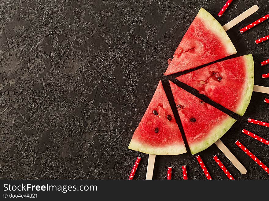 Sliced juicy watermelon on textured concrete background. Top view with copy space