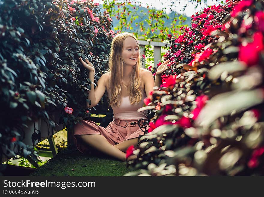 Young woman in a flower greenhouse. Bright tropical flowers..