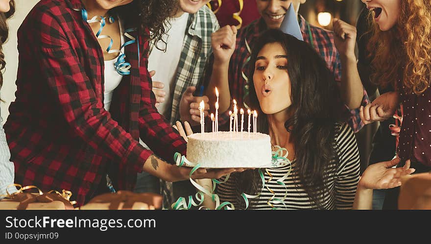 Friends making surprise with cake and canles for a birthday girl. Surprise birthday party concept