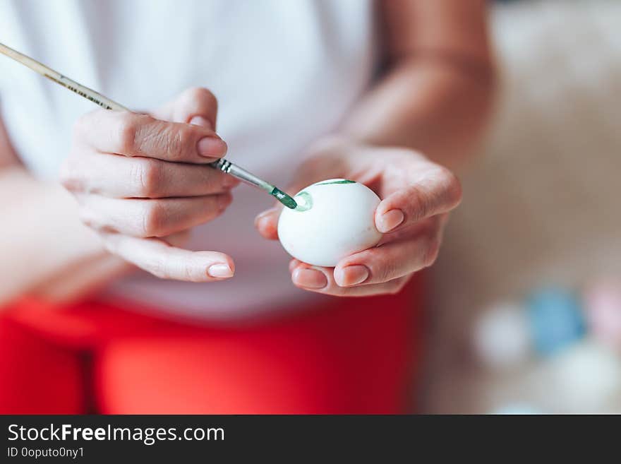 Hands painting modern style easter eggs with paint selected focus