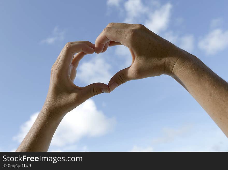 Female hands in front of blue sunny sky, vacation background. Female hands in front of blue sunny sky, vacation background