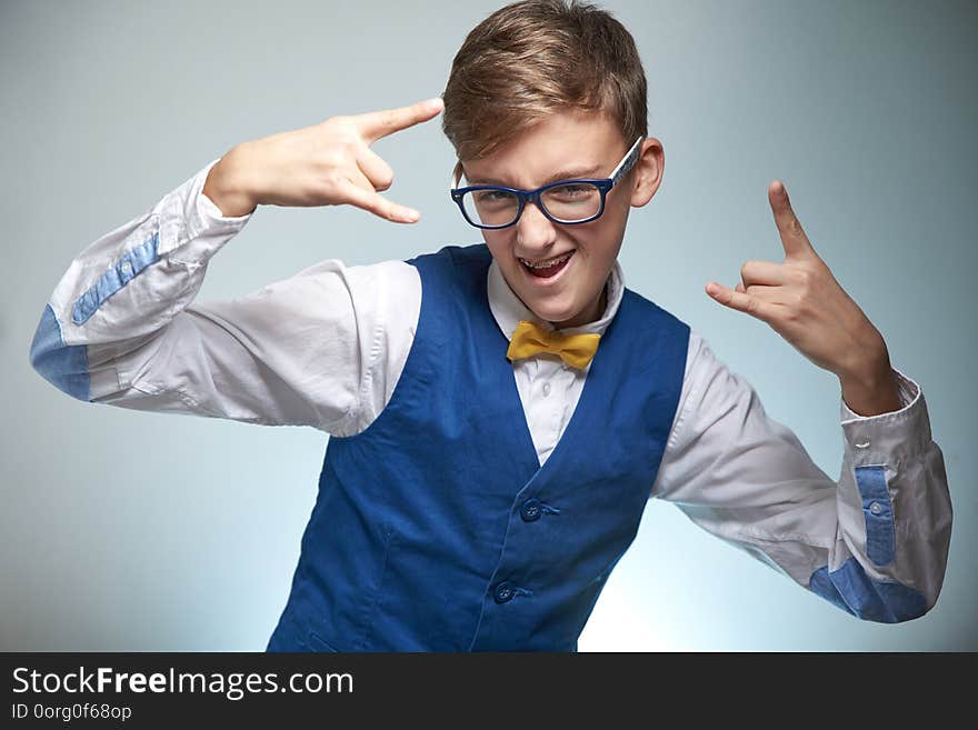 Boy teenager with braces in glasses. Wearing a shirt with a bow tie. On the teeth of dental braces