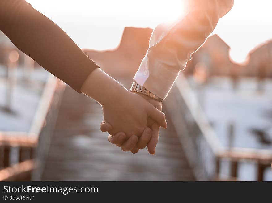 Couple holding they`re hands in the sunshine