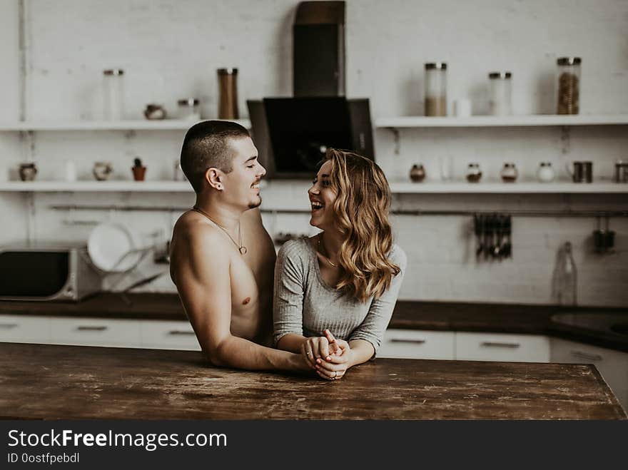 Authentic Beautiful Loving Couple Are Kissing And Hugging In The Kitchen