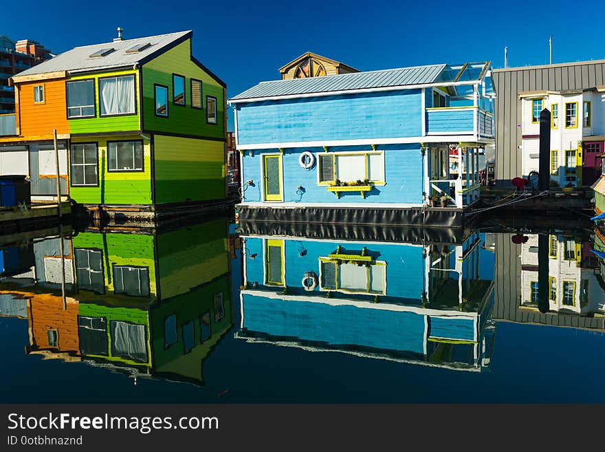 Colorful village of float homes on bright sunny day, blue sky.