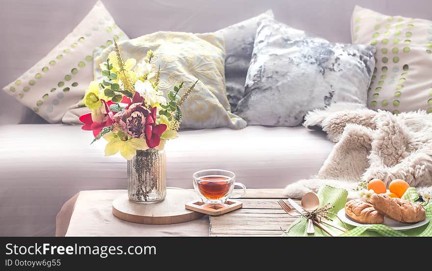 Homely cozy spring interior in the living room with a vase and flowers homemade breakfast, home comfort concept