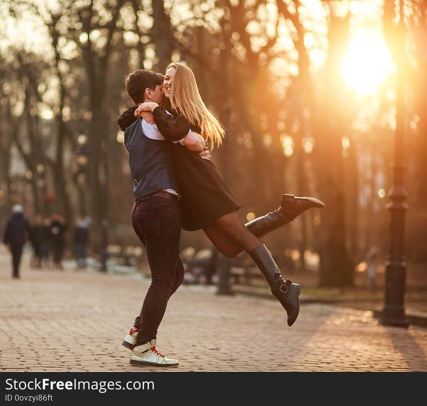 Elegant young couple in love in a classic style passionately dancing in the city park at sunset. Elegant young couple in love in a classic style passionately dancing in the city park at sunset