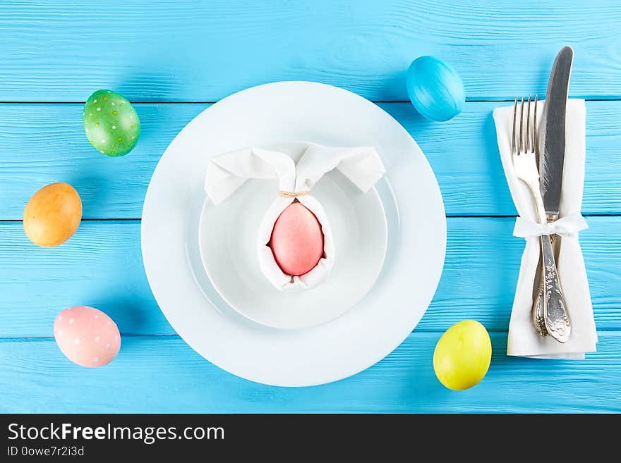 Table setting arrangement in minimal style with easter spring holiday attributes, fork, knife and napkin. Background, copy space, close up, flat lay, top view. Table setting arrangement in minimal style with easter spring holiday attributes, fork, knife and napkin. Background, copy space, close up, flat lay, top view