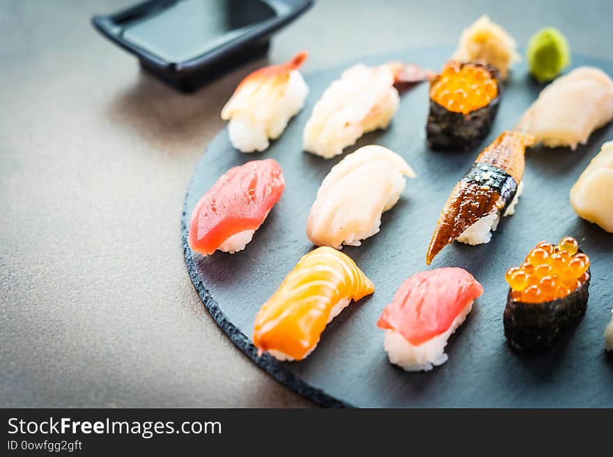 Nigiri sushi set with salmon tuna fish shrimp prawn eel shell and other sashimi on black slate - Japansese food style. Nigiri sushi set with salmon tuna fish shrimp prawn eel shell and other sashimi on black slate - Japansese food style