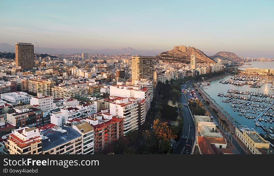 Aerial photography drone view Alicante cityscape above panorama main landmark in city center Santa Barbara castle on the Mount Benacantil moored yachts in the harbour Mediterranean sea at sunset, busy road along seaside, copy space. Spain. Aerial photography drone view Alicante cityscape above panorama main landmark in city center Santa Barbara castle on the Mount Benacantil moored yachts in the harbour Mediterranean sea at sunset, busy road along seaside, copy space. Spain