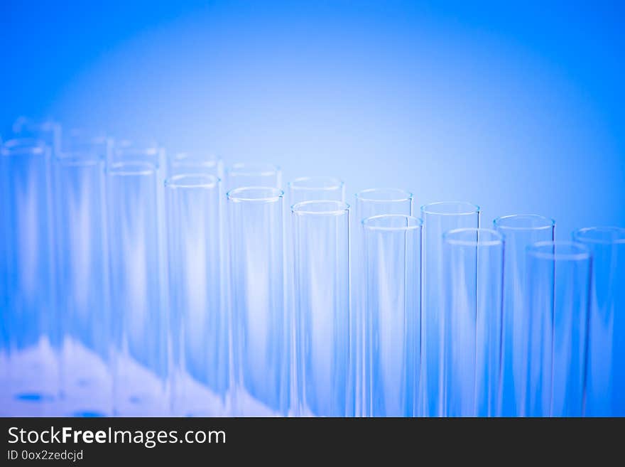 Laboratory test tubes,science background abstract. Glass test tubes in a stand on blue background