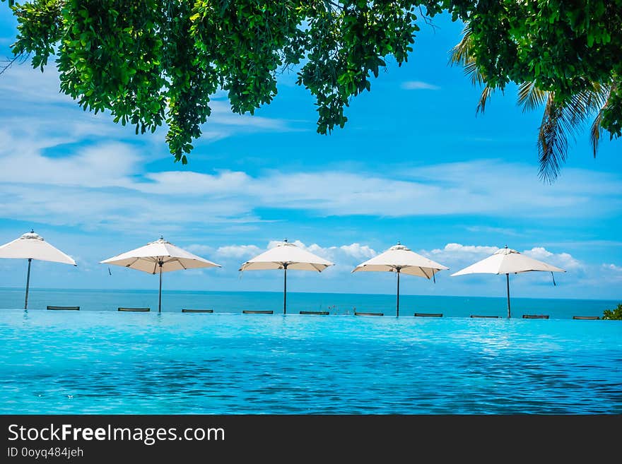 Beautiful luxury umbrella and chair around swimming pool in hotel and resort