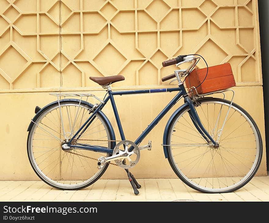 Beautiful retro bicycle set against a wall and equipped with a wooden box to carry stuff