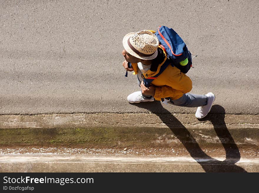 Portrait from above of male hiker with backpack walking on street