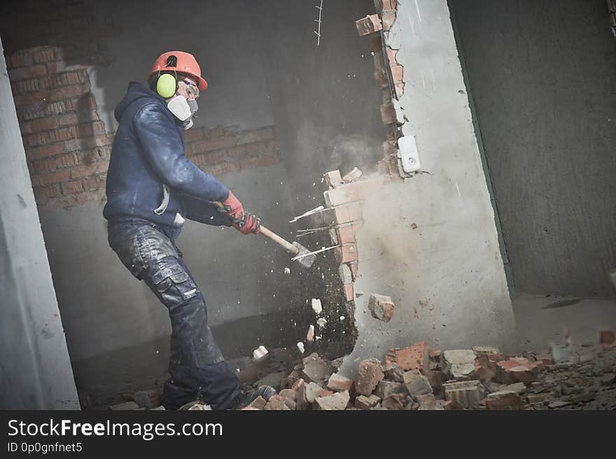 Demolition work. Worker builder with sledgehammer destroying interior wall. Rearrangement during renovation. slow motion. Demolition work. Worker builder with sledgehammer destroying interior wall. Rearrangement during renovation. slow motion