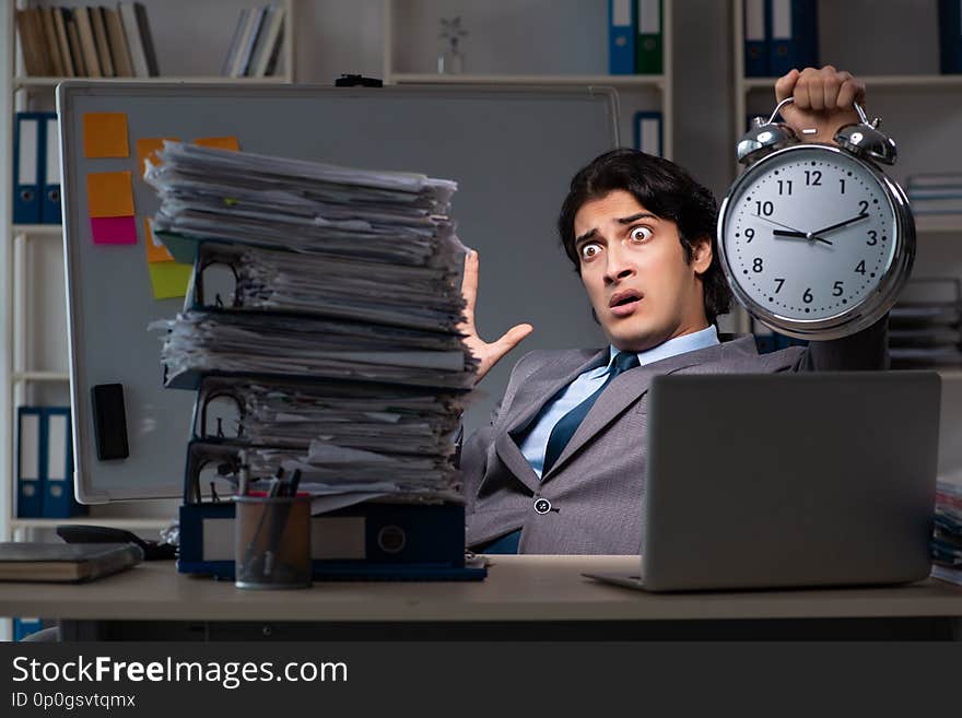 The young male employee working late at office