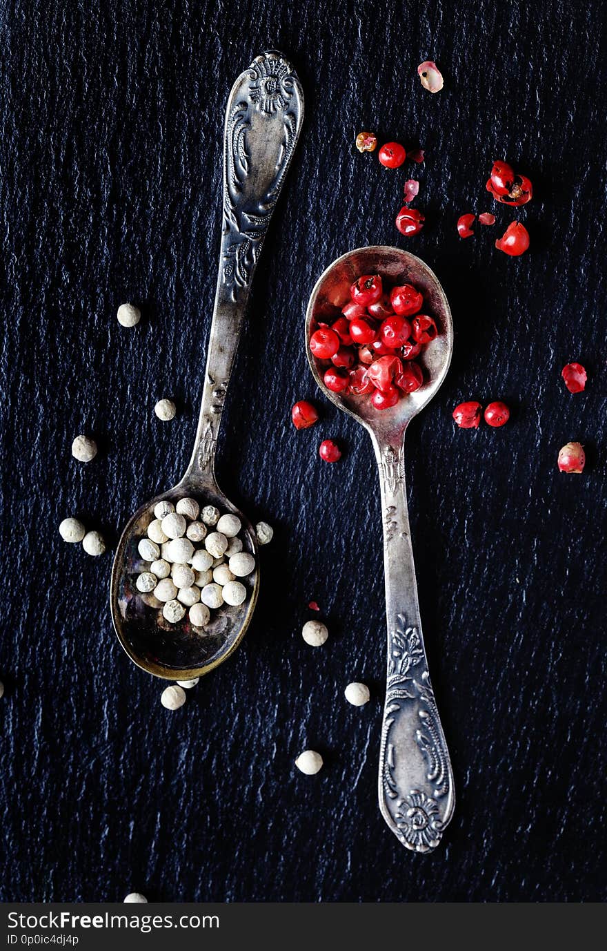 White and pink peppers in spoons