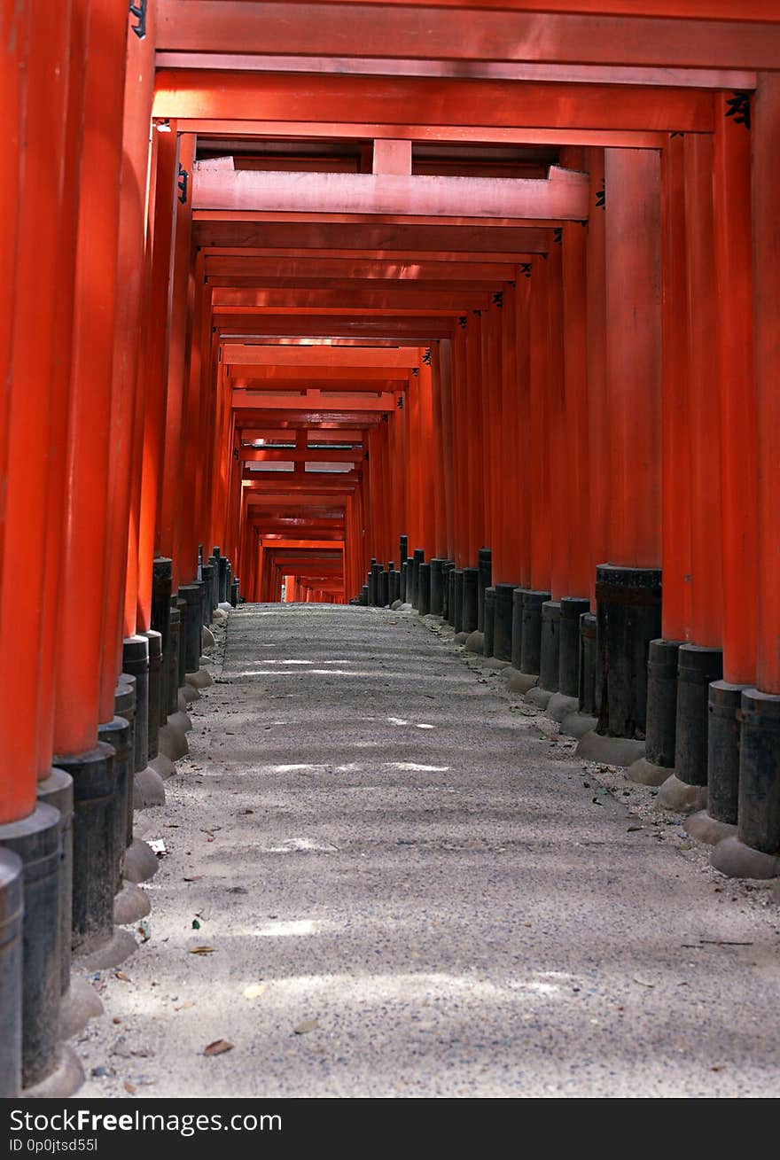 Japanese shrine entrance with red columns and black roofs background