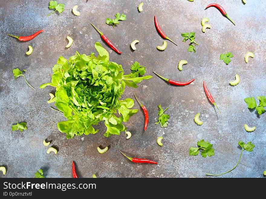 Pattern made of fresh vegetables and big lettuce buncheson dark stone background.