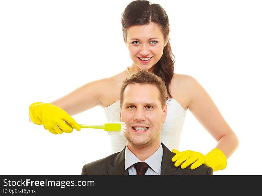 Taking care of house together, sharing household duties concept. Bride in wedding dress and groom wearing elegant suit holding cleaning equipment and tools. Taking care of house together, sharing household duties concept. Bride in wedding dress and groom wearing elegant suit holding cleaning equipment and tools