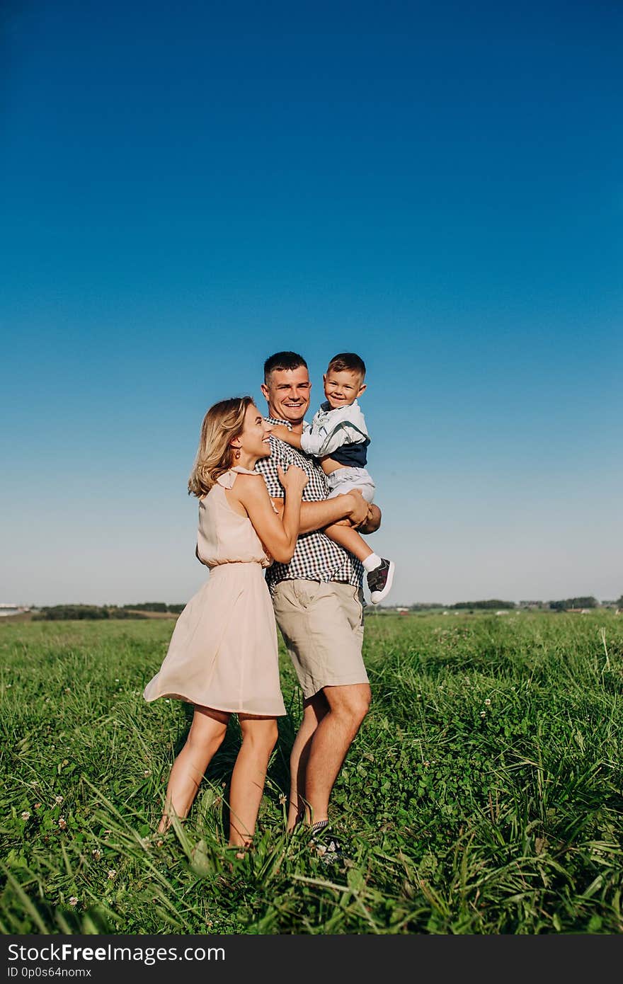 Family walking in field carrying young baby boy