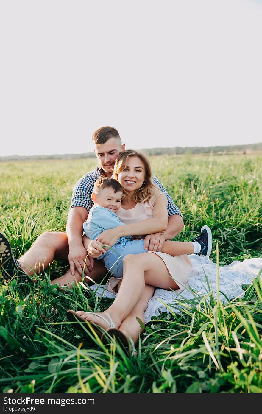 Happy family enjoying together in summer day. Family sitting on grass