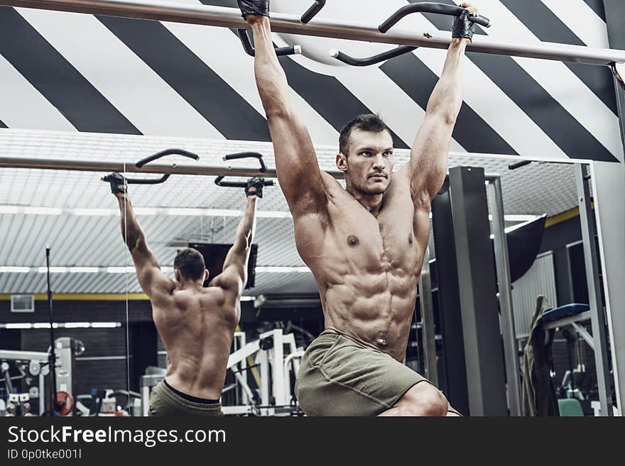 Guy bodybuilder , perform exercise do chin-ups, horizontal bar in gym. Guy bodybuilder , perform exercise do chin-ups, horizontal bar in gym