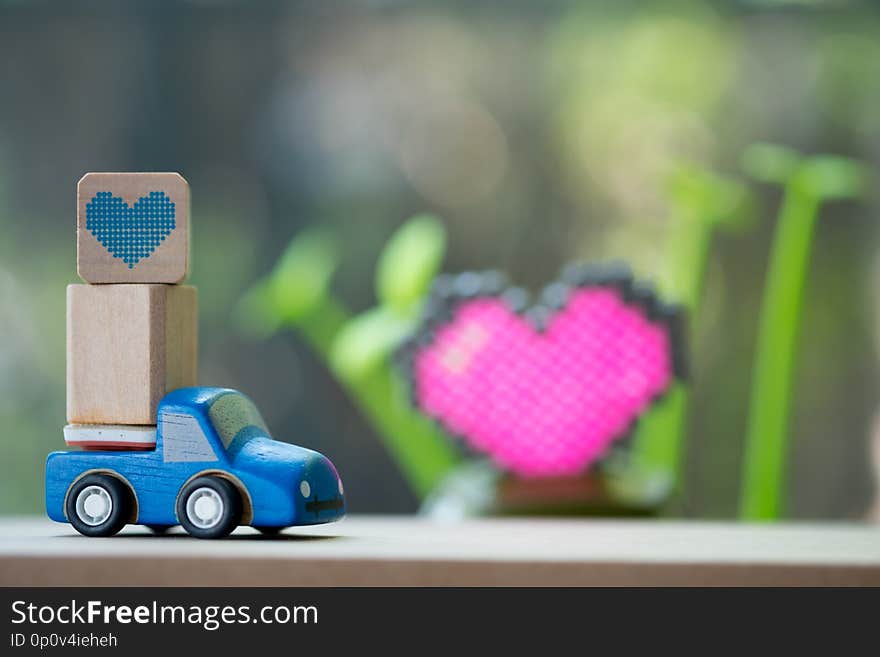 Miniature toy car carrying a heart delivering for Valentine`s day. Miniature toy car carrying a heart delivering for Valentine`s day