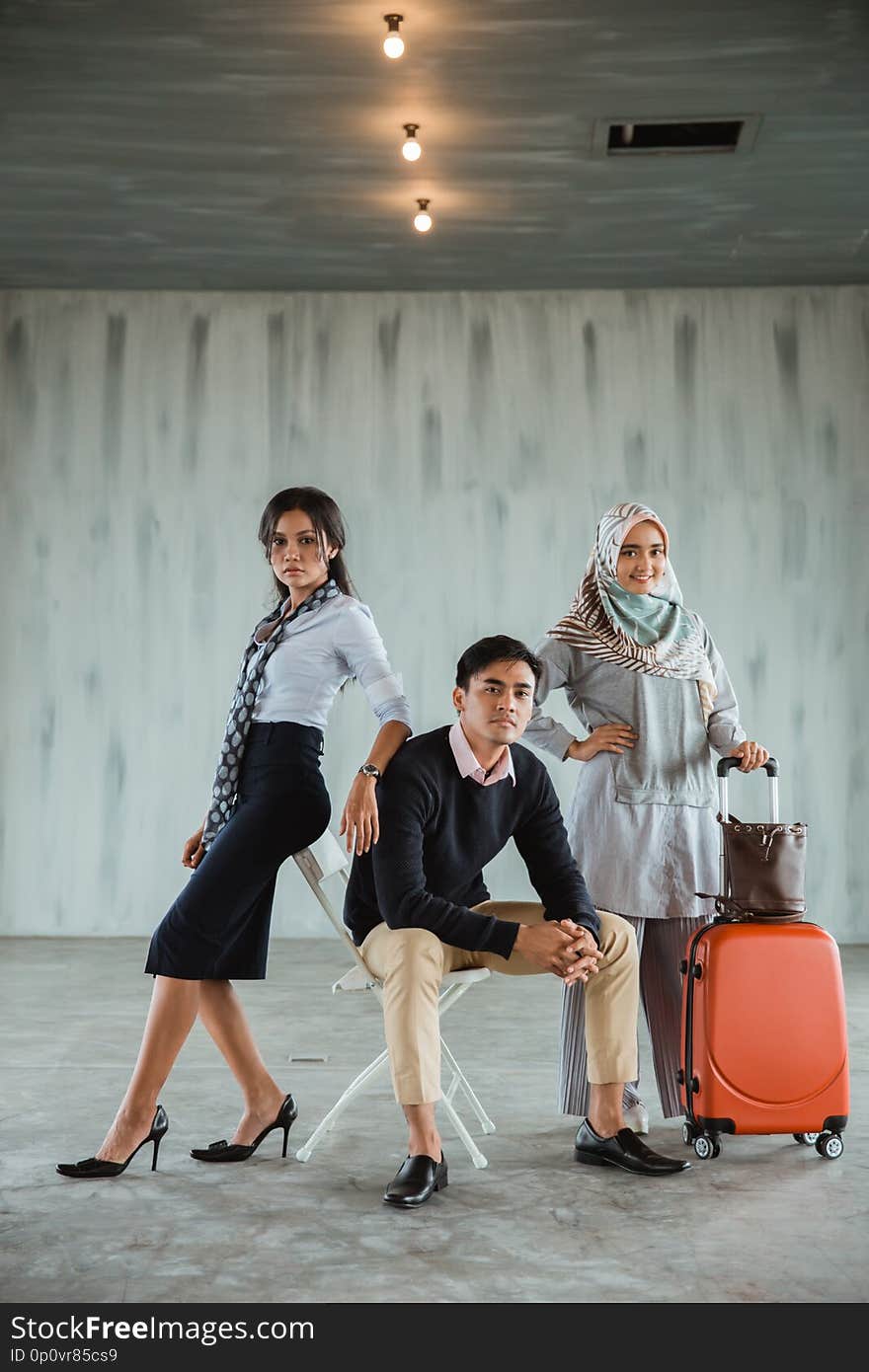 Three confident model wearing casual clothes pose in the hall