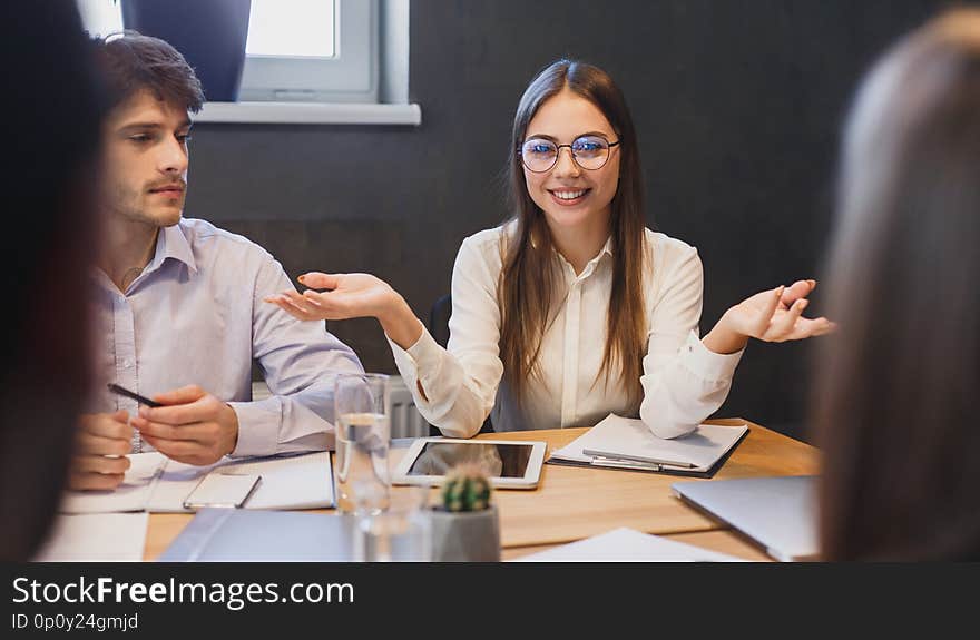 Manager explaining new ideas to colleagues at meeting in board room