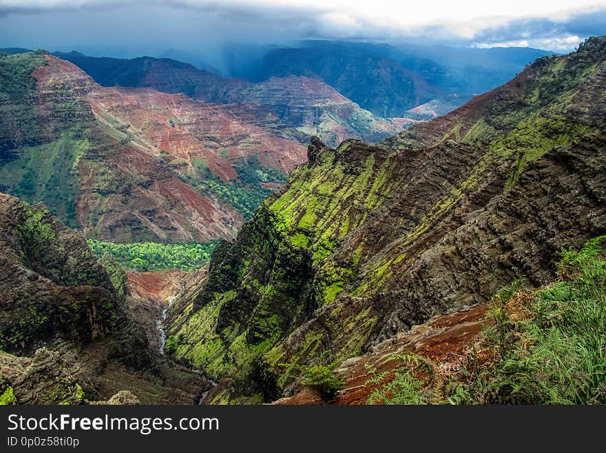 Spectacular view of Waimea Canyon State Park on a cloudy day with waterfall and river, Kauai, Hawaii