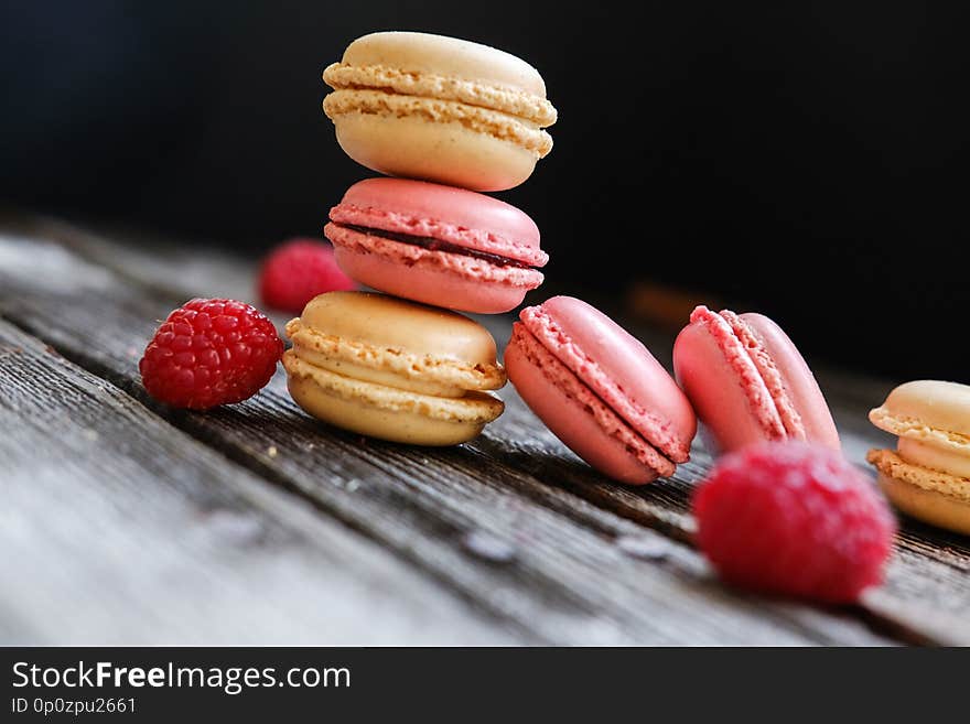 Close-up photo. Colorful French macarons with raspberries on a table