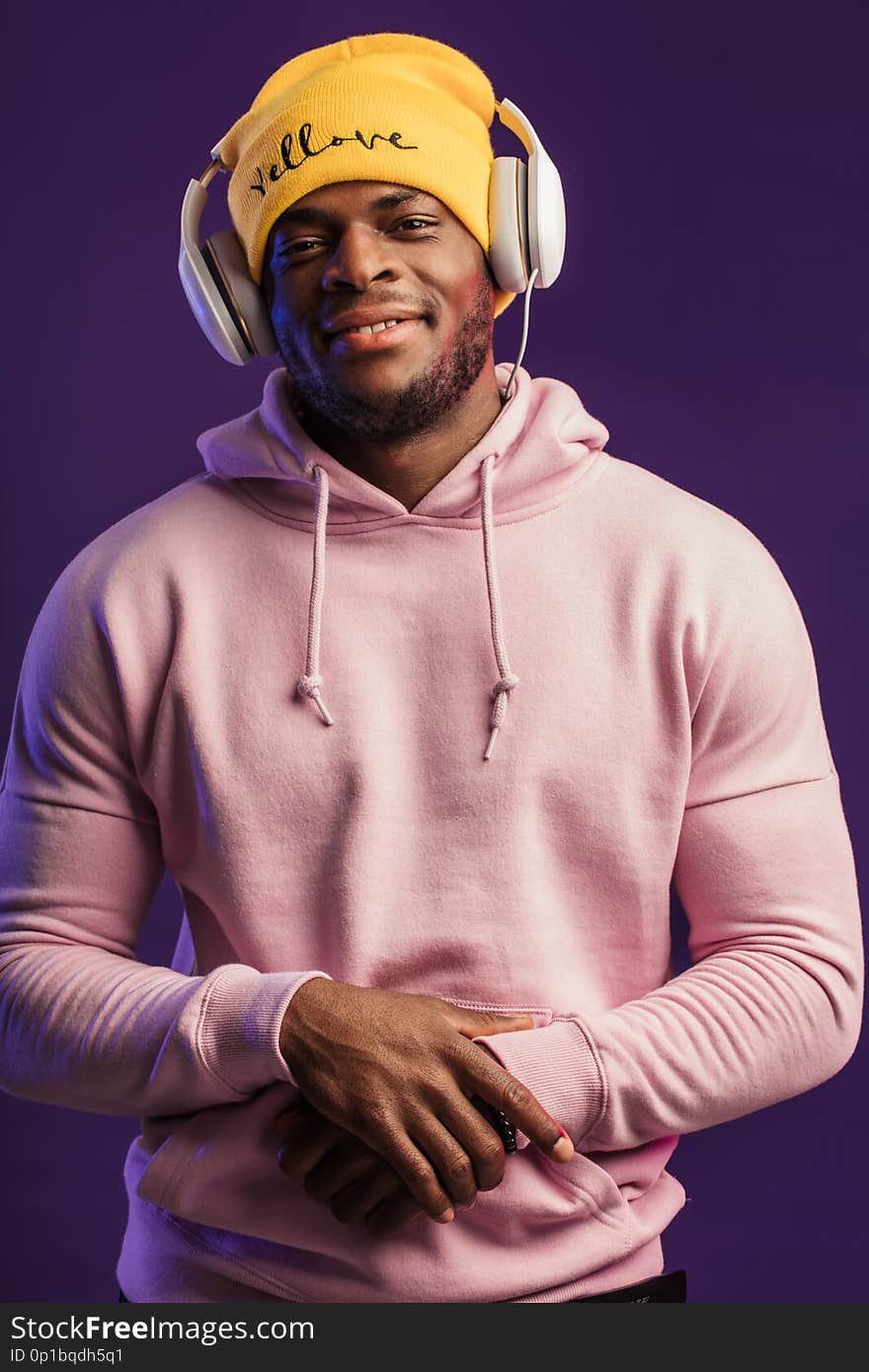 African man in hoodie with headphones isolated, happy expression. Music, people