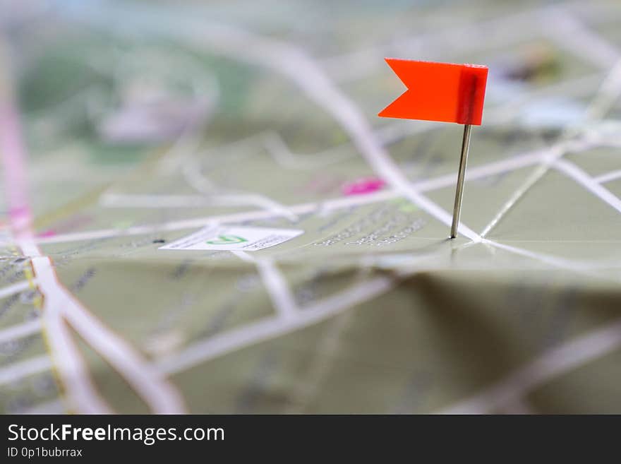 Travel concept: a red flag pinned to a landmark on a paper map