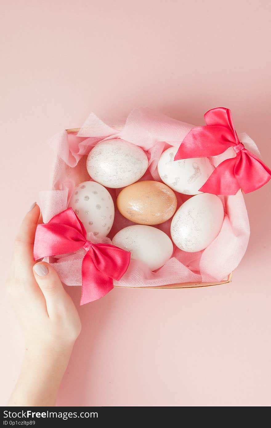 White Easter eggs in a nest on pink background. Design pastel tone in minimal flat lay