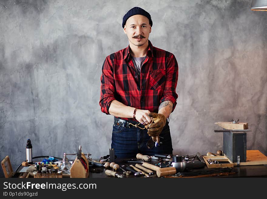 Attractive man is standing at the table and looking at the camera