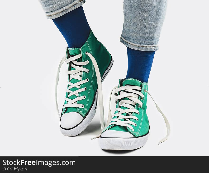 Office Manager, stylish sneakers, blue pants, multicolored, variegated socks. White, isolated background. Close-up. Concept of fashion and elegance. Office Manager, stylish sneakers, blue pants, multicolored, variegated socks. White, isolated background. Close-up. Concept of fashion and elegance