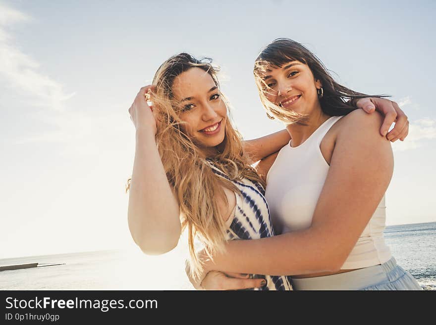 Two young beauty women hug like a couple looking at the camera and look at themselves