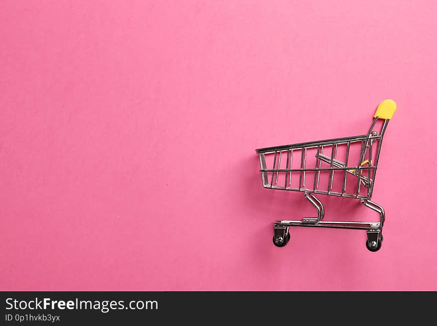 Shopping cart on a pink background with space for text