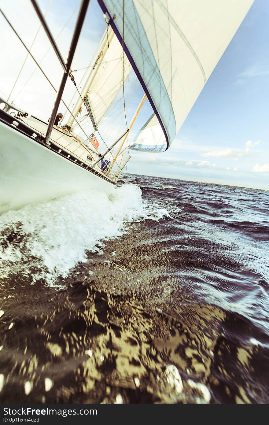 Yachting on sail boat bow stern shot splashing sea water. Sporty transportation conept. Yachting on sail boat bow stern shot splashing sea water. Sporty transportation conept