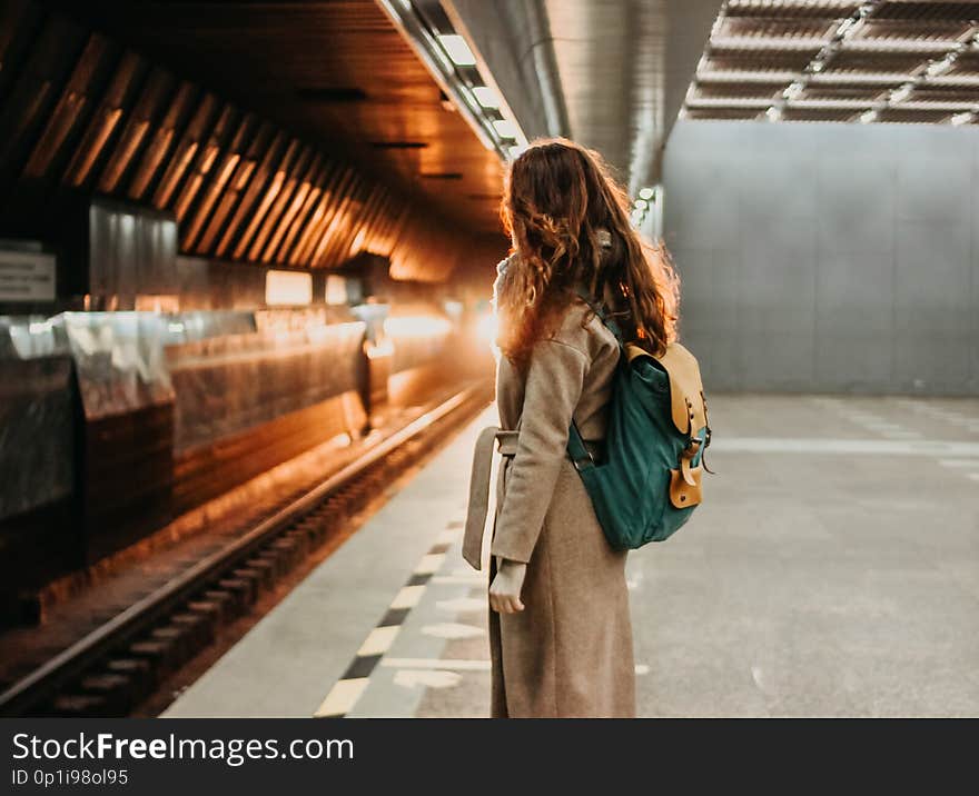 Young woman curly red head girl traveller with backpack and map in subway station