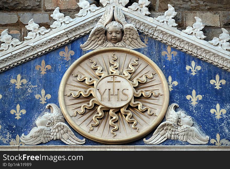 Medallion with the IHS monogram between two lions, above to the entrance to Palazzo Vecchio, a UNESCO World Heritage Site in Florence, Italy. Medallion with the IHS monogram between two lions, above to the entrance to Palazzo Vecchio, a UNESCO World Heritage Site in Florence, Italy