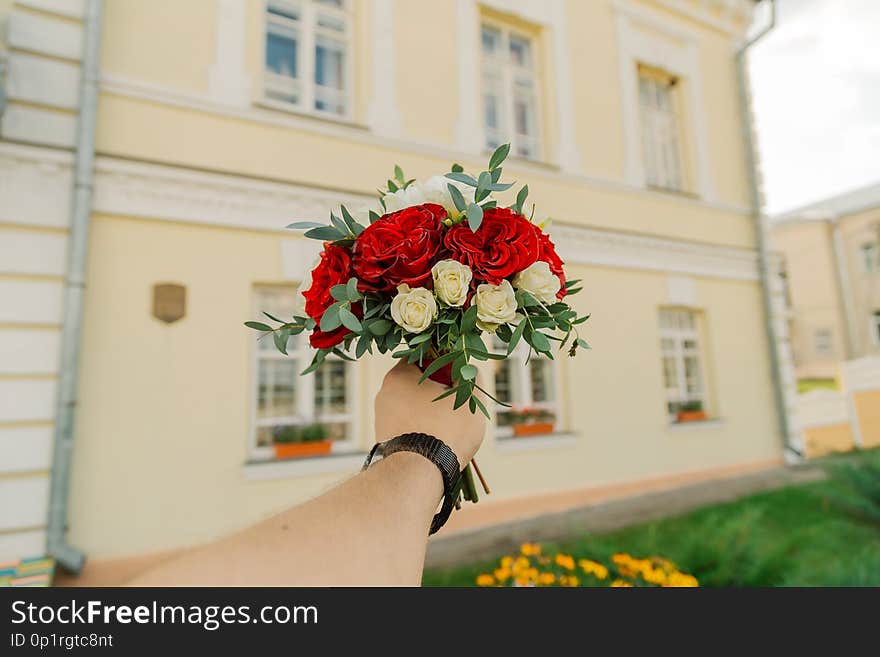 Wedding fresh bouquet in a man`s hand.