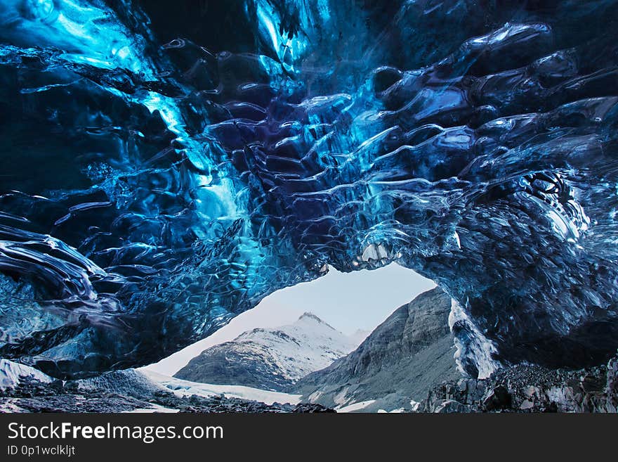 Amazing ice cave. Blue crystal ice cave and an underground river beneath the glacier. Amazing nature of Skaftafell.