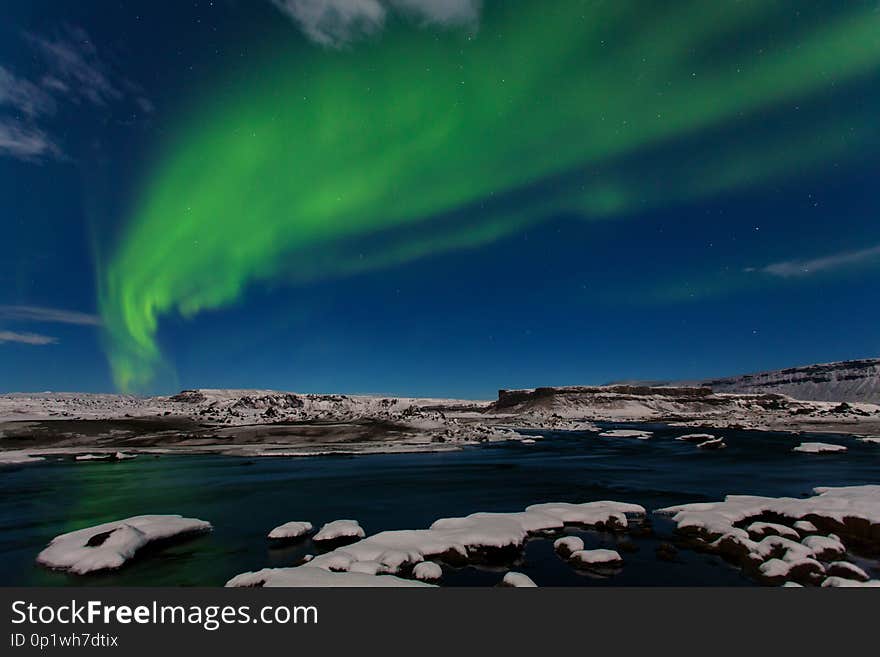 Aurora borealis above the sea. Jokulsarlon glacier lagoon, Iceland. Green northern lights. Starry sky with polar lights. Night winter landscape with aurora, sea with sky reflection in water. Nature, places near glacier lagoon Jokulsarlon Ice rock with black sand beach in southeast Iceland. Most popular place in Golden circle.