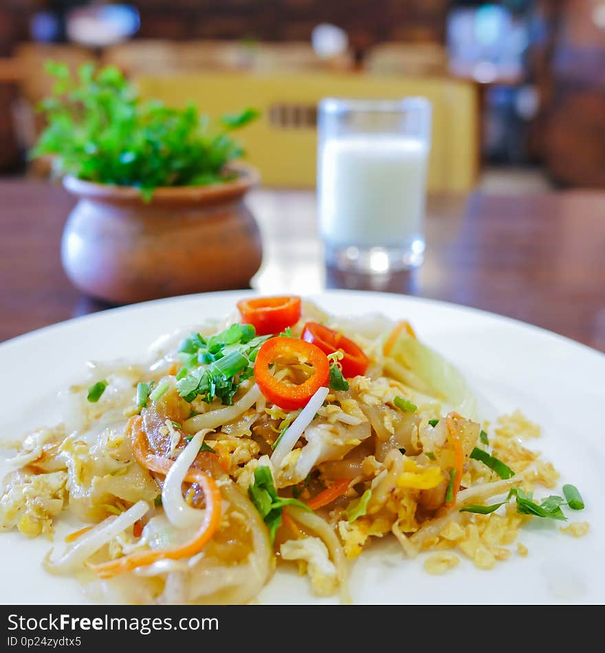 Closeup of chinese food, Fried noodle mixed with egg and vegetables on white plate-soft focus