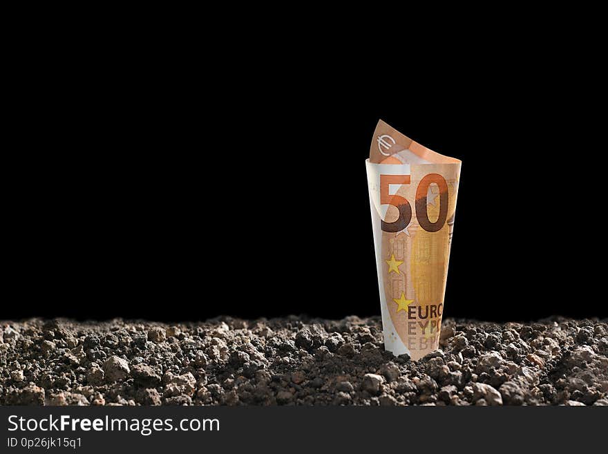 Image of EURO money banknote on top of soil for business, saving, growth, economic concept isolated on black background