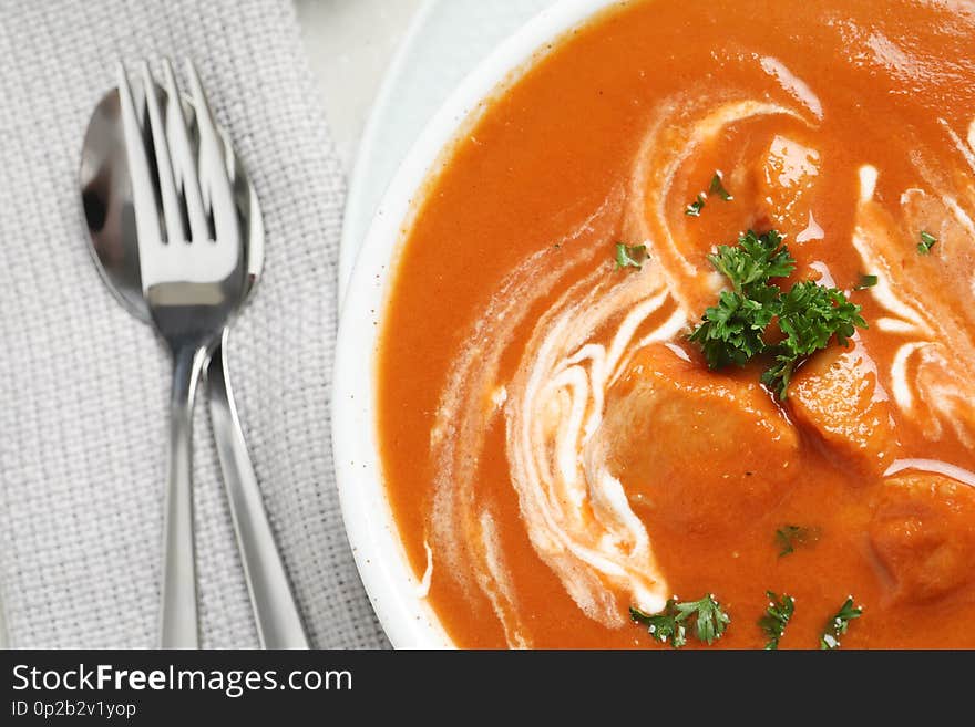 Delicious butter chicken served on table, top view.