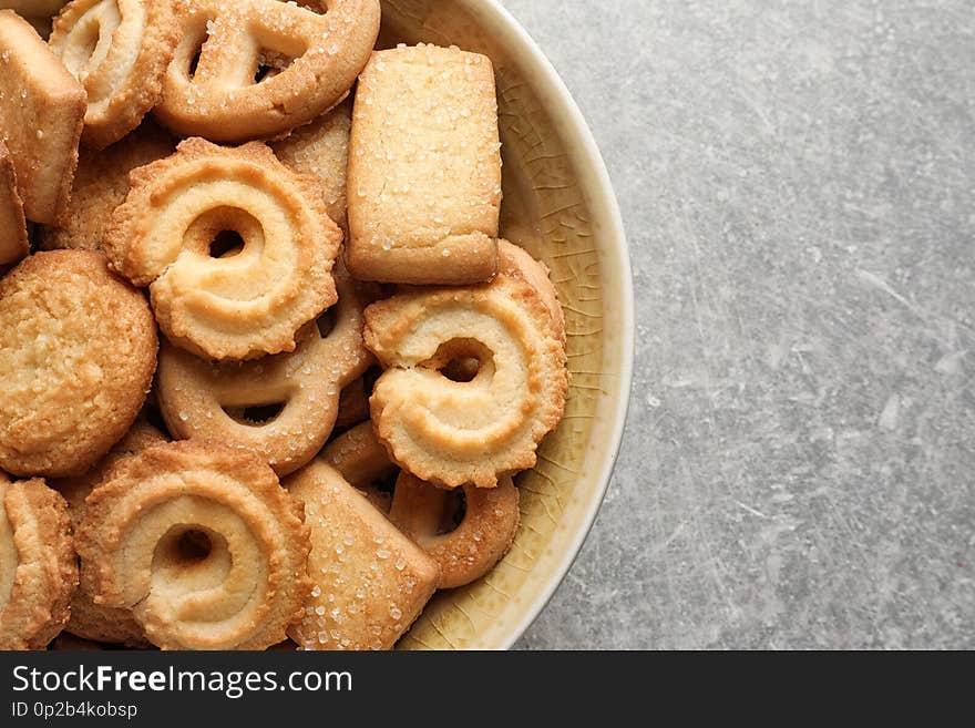 Bowl with Danish butter cookies on grey background, top view. Space for text