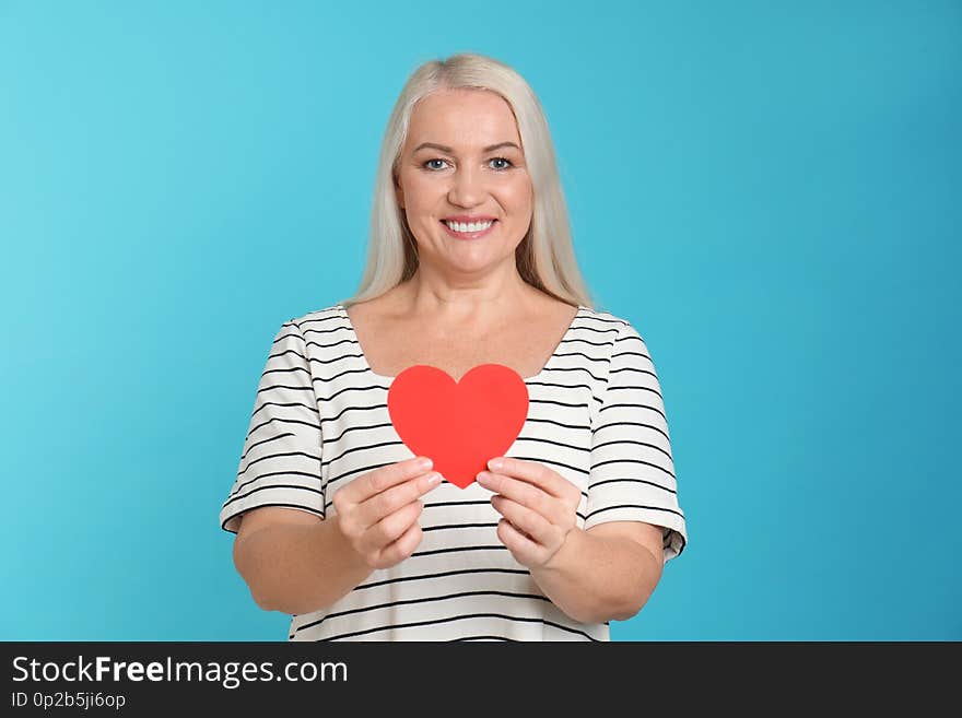 Portrait of mature woman with decorative paper heart